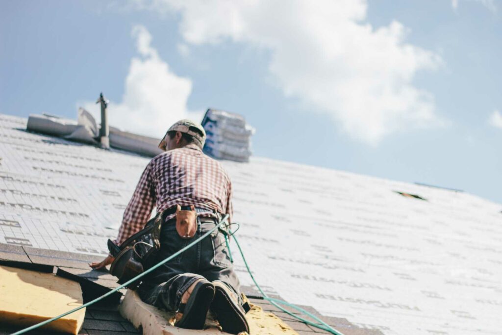 Professional roofer putting shingles on a roof.