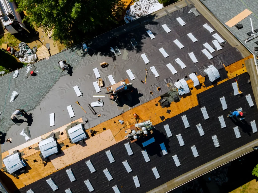 Aerial view of workers on a roof, showcasing some of the 8 Best Roofing Safety Tips for Workers