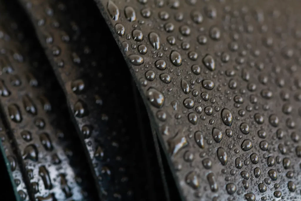 Closeup of water drops on a rubber material, showing a popular material in eco-friendly commercial roofing solutions