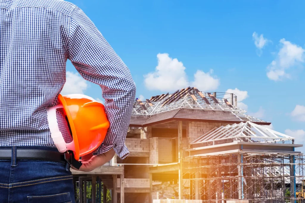 Commercial Flat Roof. engineer holding yellow safety helmet at new home building under construction site