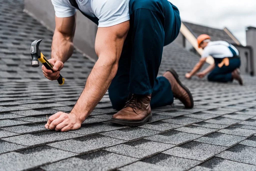 Workers fixing a roof, showcase some Key Preventive Maintenance Steps for Industrial Roofs