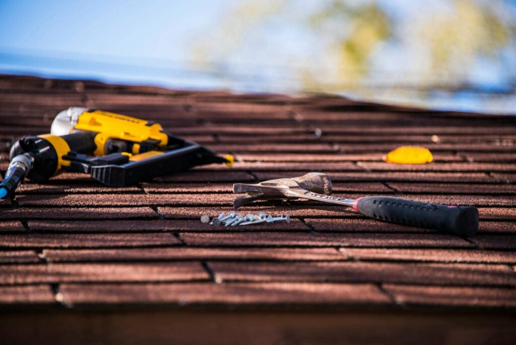 Tools on a roof for inspection|Person inspecting roof with ladder.|Workers installing roofing under blue sky.|Hand placing roofing shingles on roof|Workers installing roofing materials outdoors.|Workers repairing a roof in autumn.|Worker installing tiles on roof|Person installing shingles on a roof|Top Durable Roofing Materials for Longevity|Person inspecting mossy roof shingles|Worker repairing a flat roof|Person repairing a tiled roof.|Workers repairing a residential roof.|Person installing shingles on a roof|Worker repairing a tiled roof