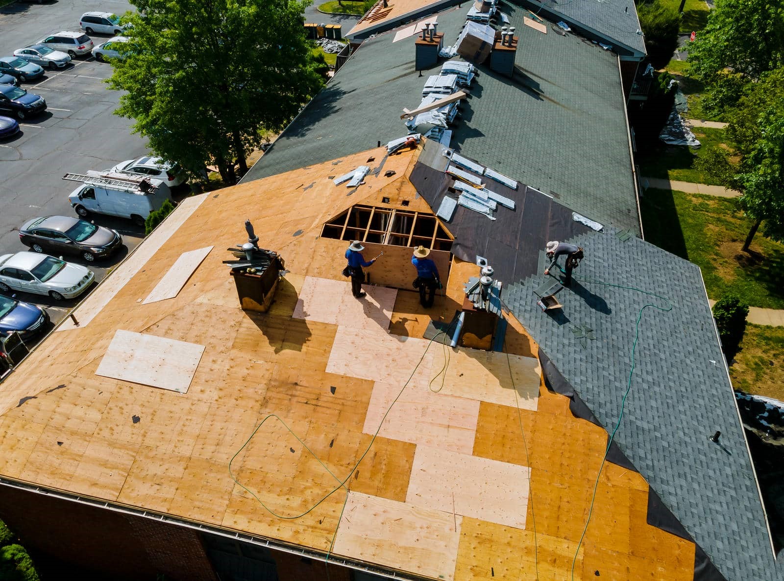 Workers installing shingles on roof