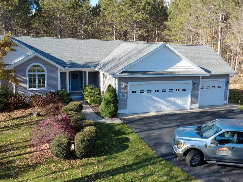 Single-story house with a three-car garage and a silver pickup truck parked in the driveway.