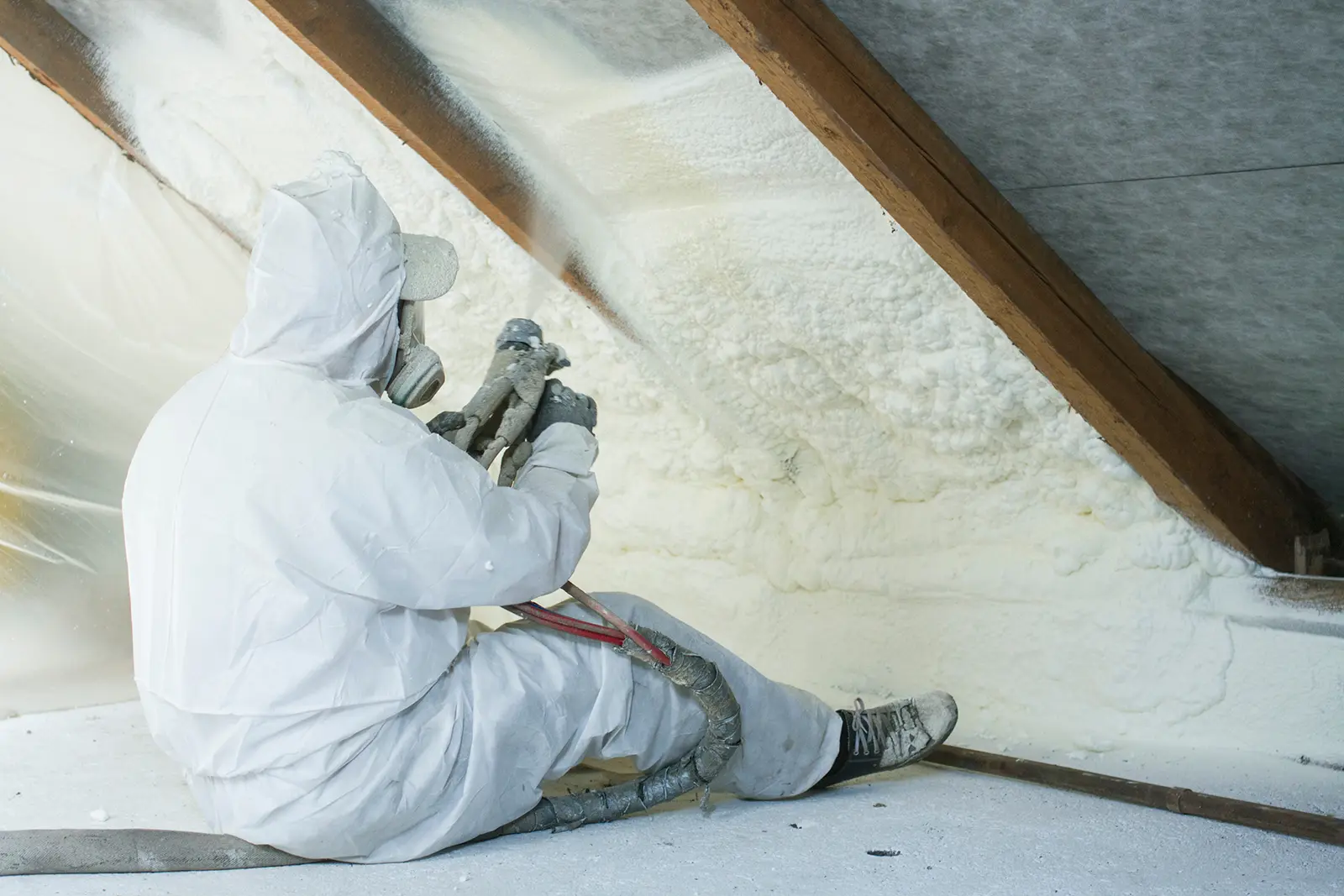 Worker applying spray foam insulation